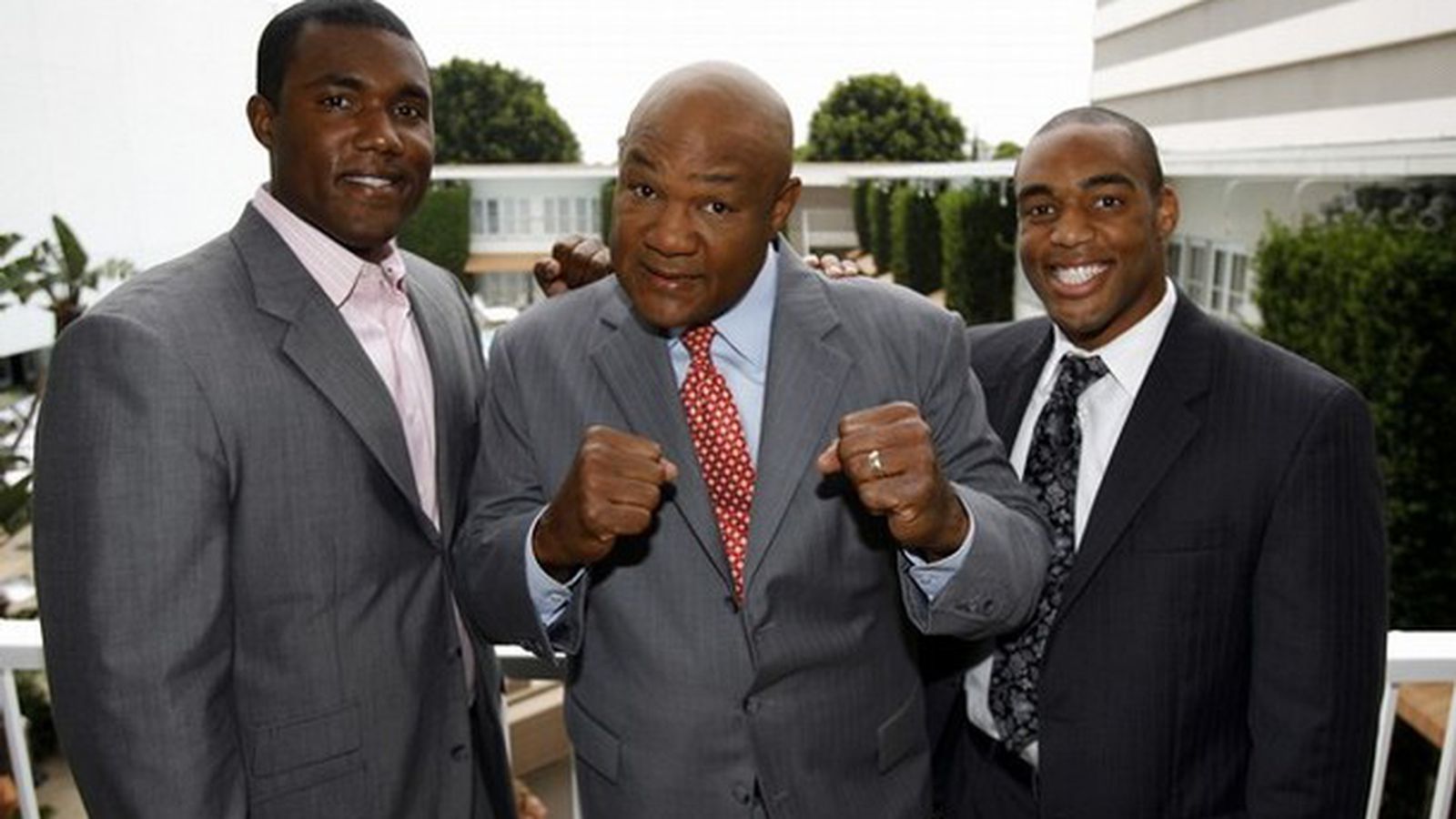 Image of George Foreman holding a Choice Home Warranty logo, smiling.
