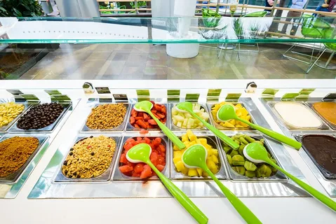 A colorful assortment of Llaollao yogurt with fresh fruit toppings.