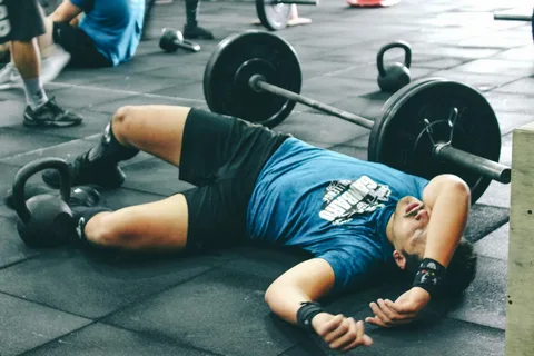 An image showing a person taking a break from exercising at the gym, with a caption suggesting modifying workouts as you age.